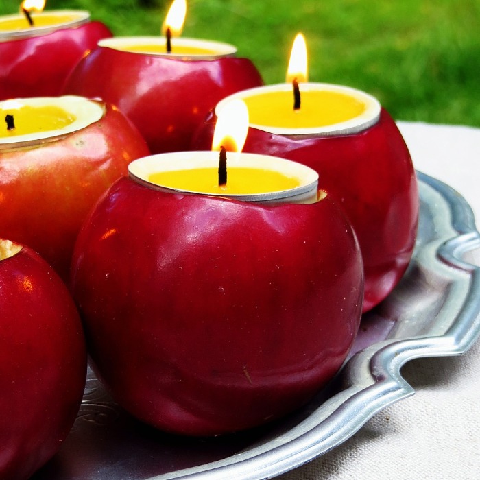 red apples with candles on a tray outside