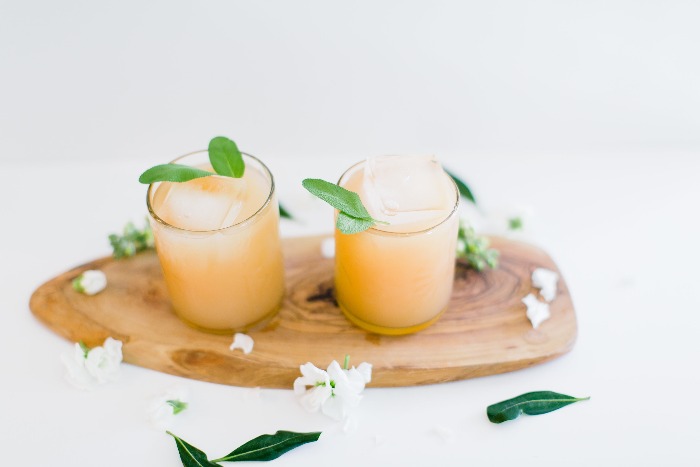 two sage cocktails decorated with sage leaves and flowers