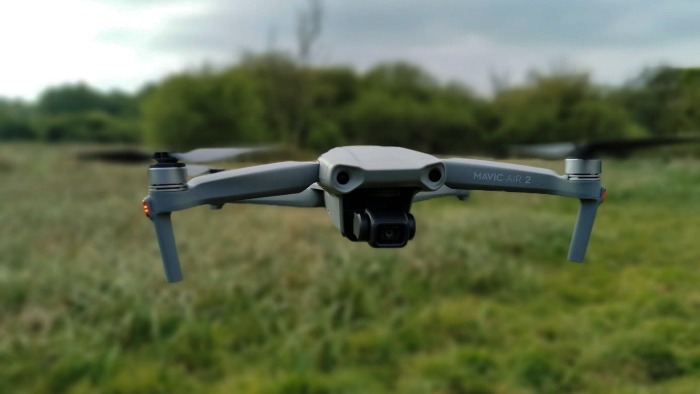 dji mavic air 2 close up drone flying over a green field