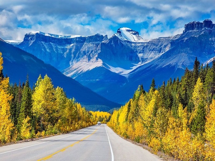 the rocky mountains canada in autumn road with snowy peaks in the background