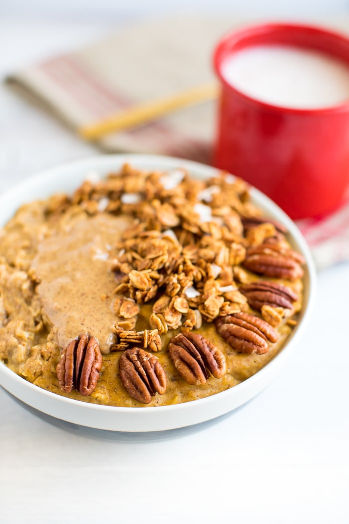 Best healthy breakfast ideas for the fall pumpkin oatmeal on a white table with red mug 