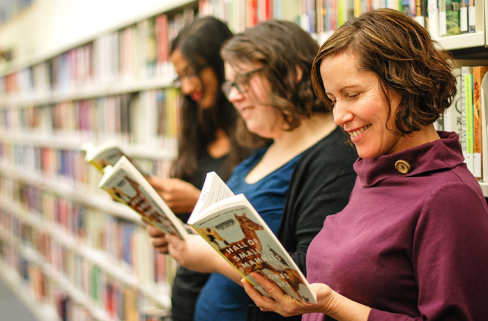 best new hobbies three women smiling and reading books at a library 