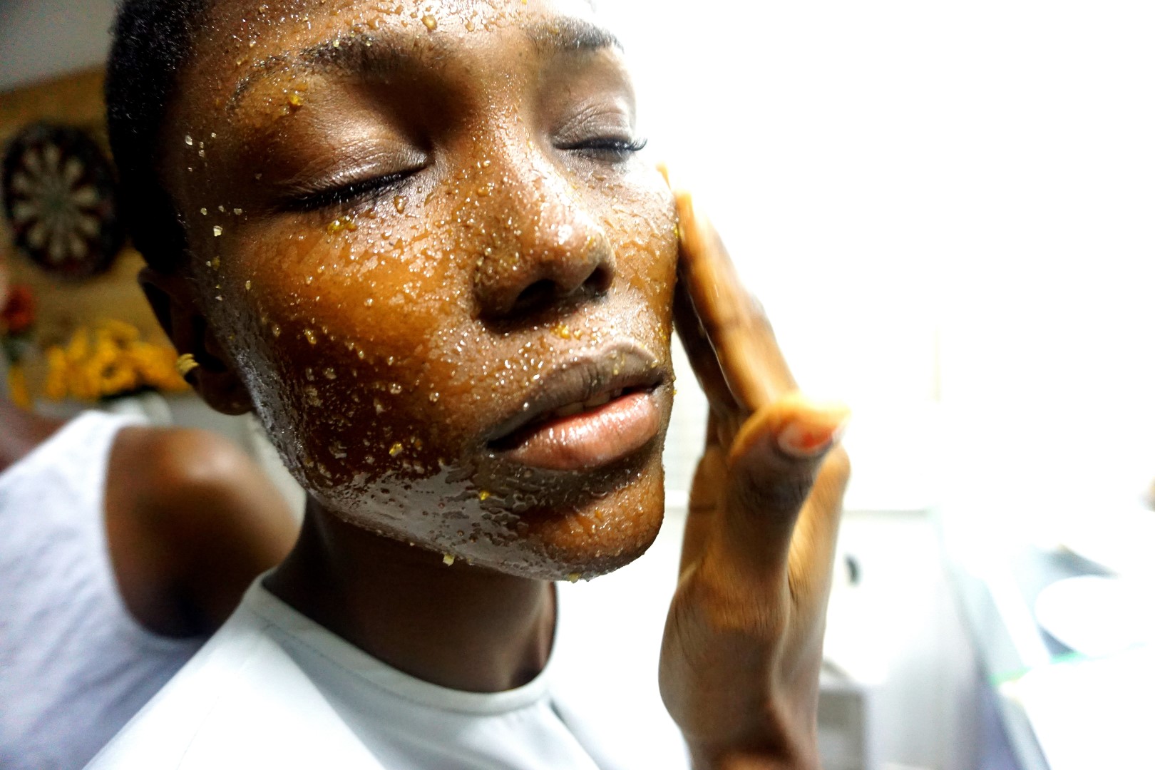 a woman putting natural cosmetics on her face sugar scrub
