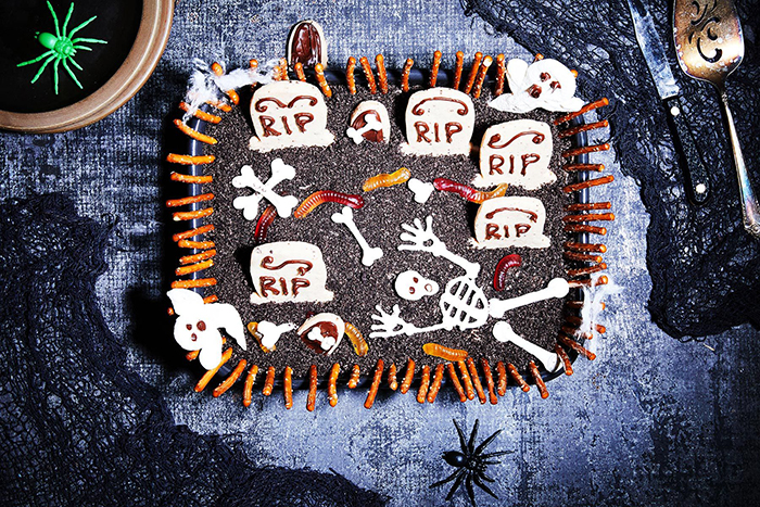 Halloween cake ideas black graveyard cake with skeletons on a black table