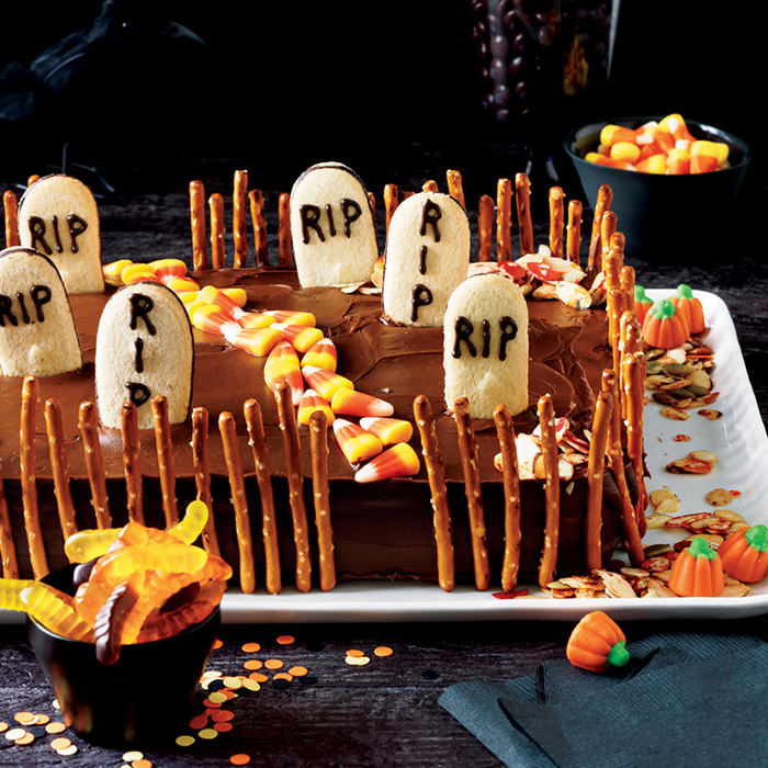 Halloween cakes graveyard surrounded with salty sticks and rich decoration