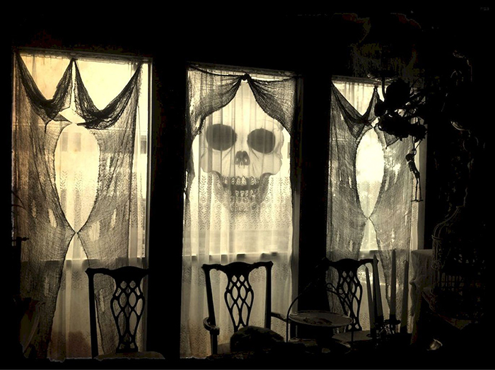 Transforming your Home for Halloween spooky window decor old curtains and a skull