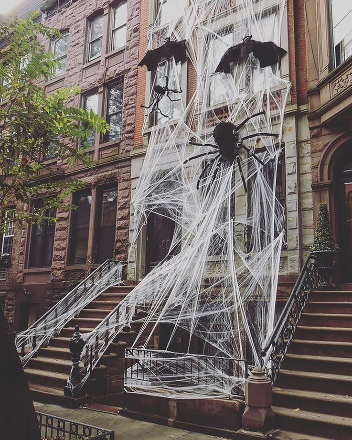 Giant spider web at the exterior of a home with bats and a big black spider