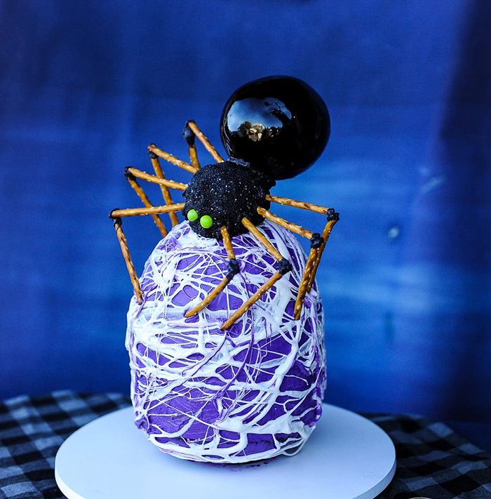 Halloween spider cake idea black spider with green eyes on a purple and white egg
