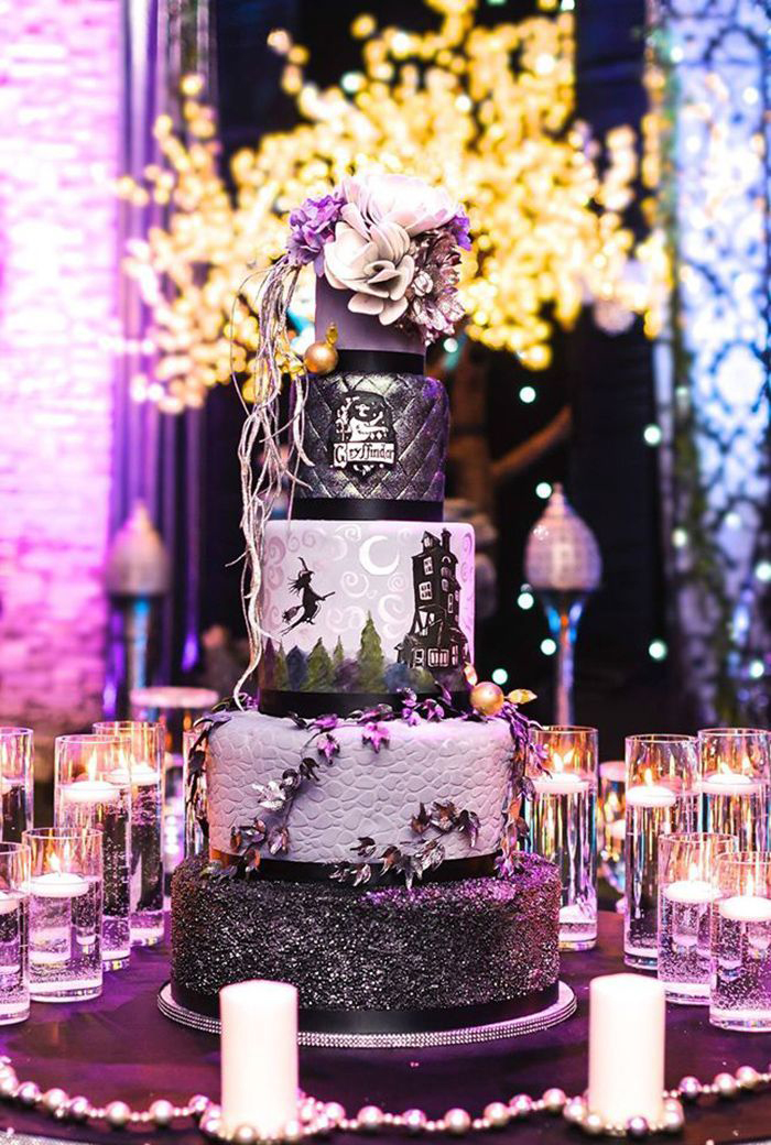 Purple and black witch halloween cake at a party with floral decorations