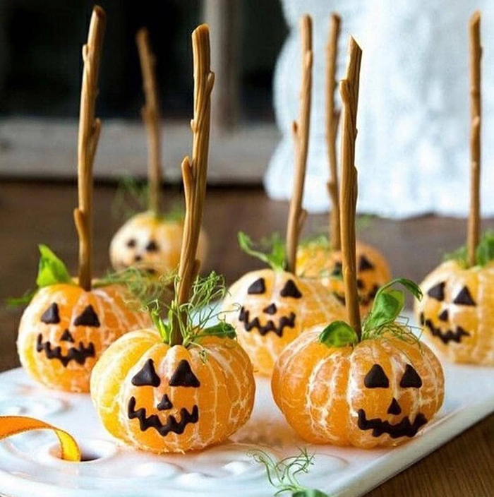 fruity pumpkin treats tangerines with chocolate faces on sticks