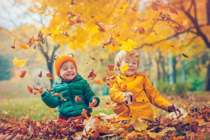 DIY Fall Wreaths two kids playing outdoors in the autumn leaves