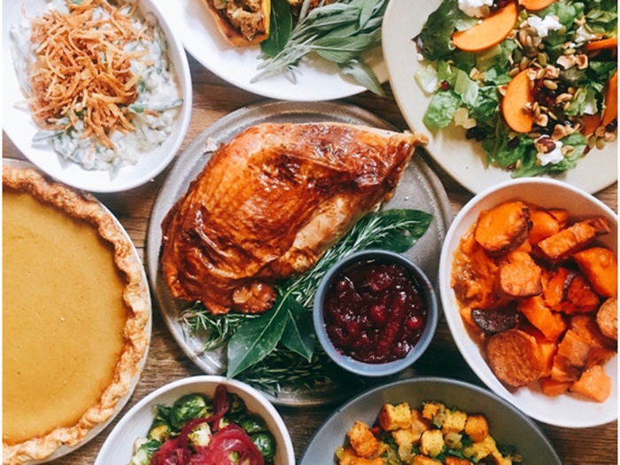 thanksgiving recipes dinner idea with piece of turkey vegetables pie salads all around