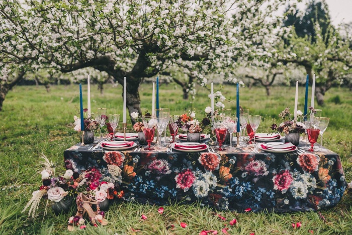 outdoor wedding decor dark table with floral print on and tall candels