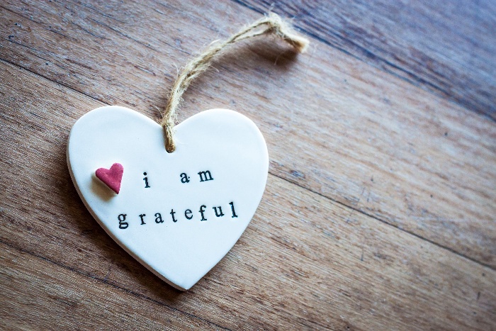 white heart with gratitude message on it on a wooden table