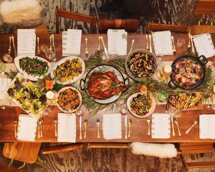 Thanksgiving celebration on a budget dining table from above with different dishes turkey at the center