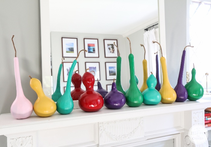 modern guards colorful gourds on a white mantel in front of a big mirror