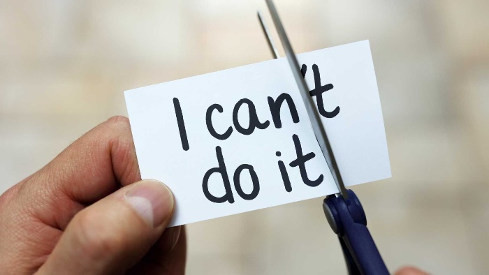 motivational affirmations man cutting a note with scissors