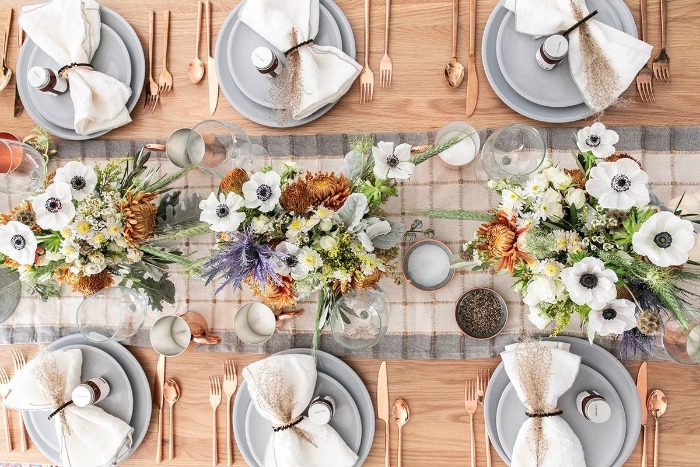 rustic modern thanksgiving table in pale blue with rose gold utencils and ribbon napkins