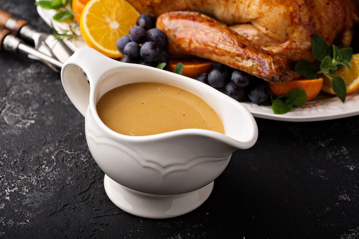 thanksgiving recipes turkey gravy in a on a table next to a turkey