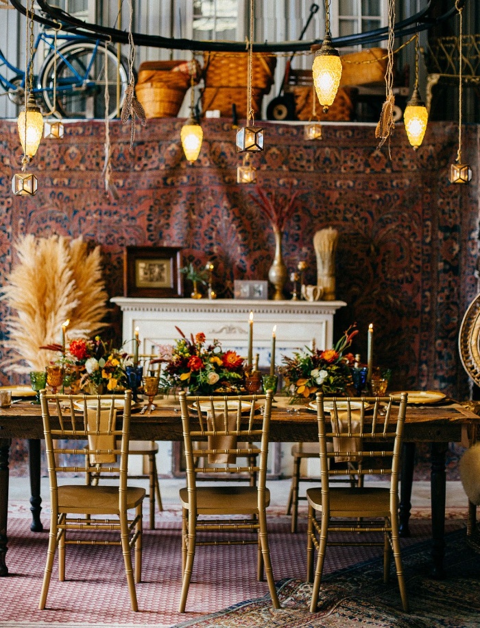 vintage wedding in rustic style table with golden chairs and floral centerpieces