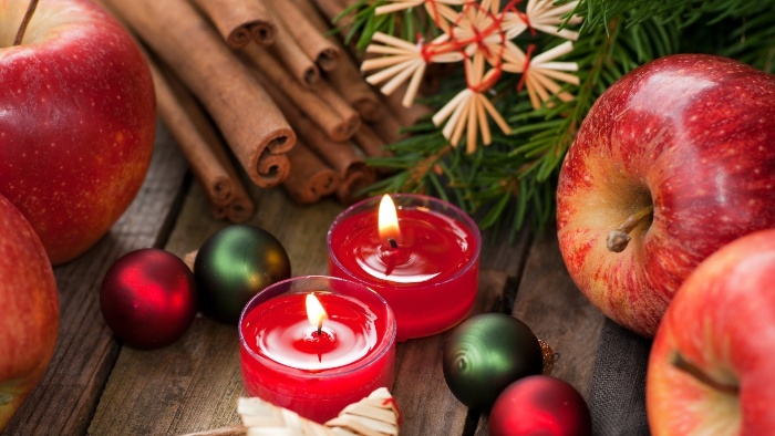 Christmas arrangement with apples cinnamon candles and christmas decorations