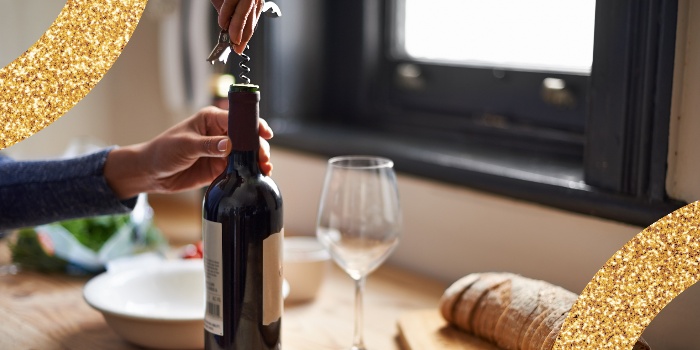 person opening a champagne bottle on a table as christmas gift