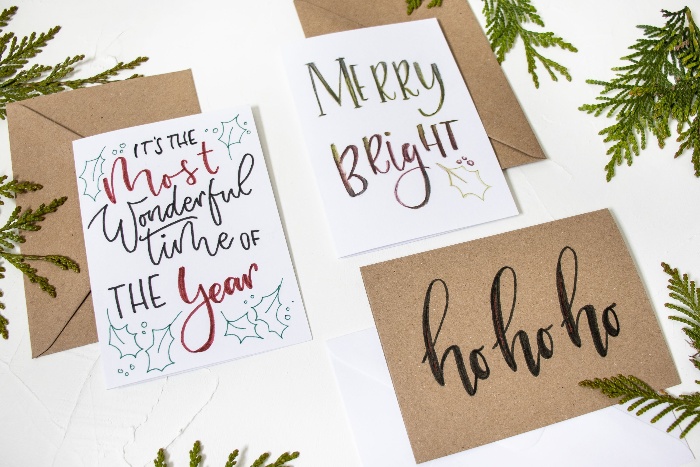 christmas cards with beautiful calligraphy on a white table