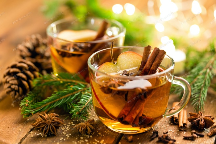 christmas tea in glass cups with cinnamon sticks star anise and apple slices