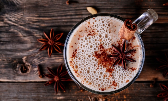 warm winter drink decorated with anise and cinnamon stick on a dark wooden table