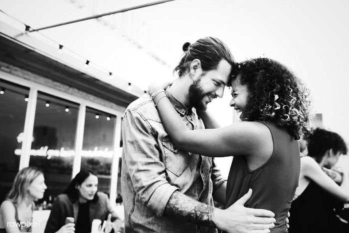 couple dancing at a party with foreheads together in a dance 