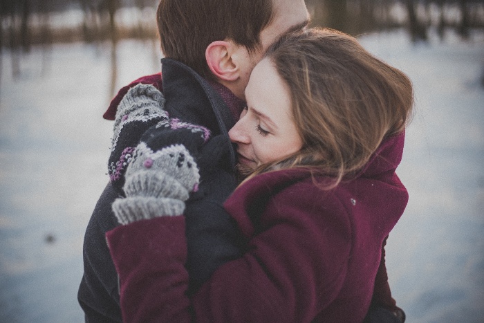 couple embracing in the snow winter hugs 