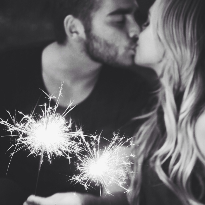 couple kissing with sparkles in their hands 