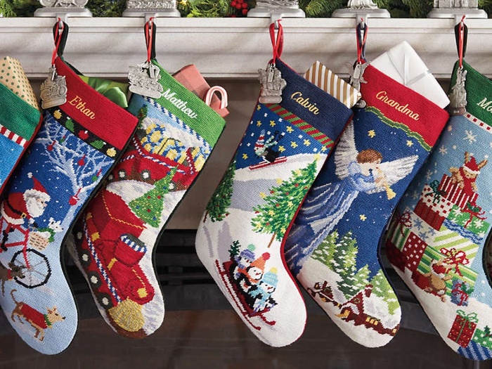 cute colorful christmas stockings hanging from a mantel above a fireplace