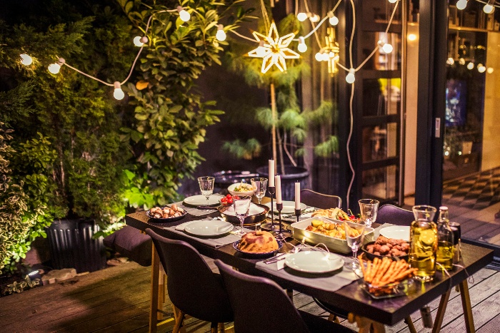 garden fairy lights over a beautiful table setting on a porch with a wooden floor