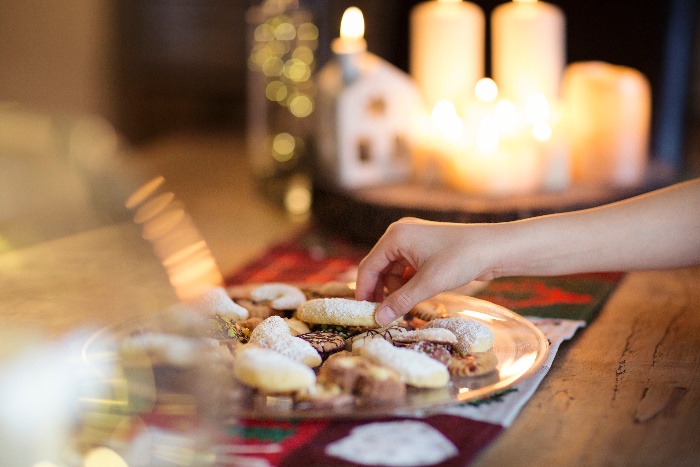 christmas cookies on a table hand picking some of them