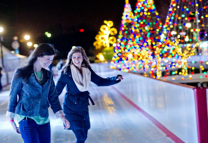 holiday fun two girls on an ice skating ring with christmas trees