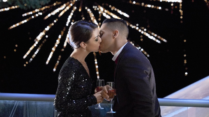 midnight kiss elegant couple kissing on a terrace with fireworks in the background