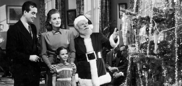 Best christmas movies a scene from a black and white christmas movie family standing in front of the christmas tree with santa claus