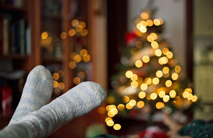 feet with socks and a christmas tree in the background