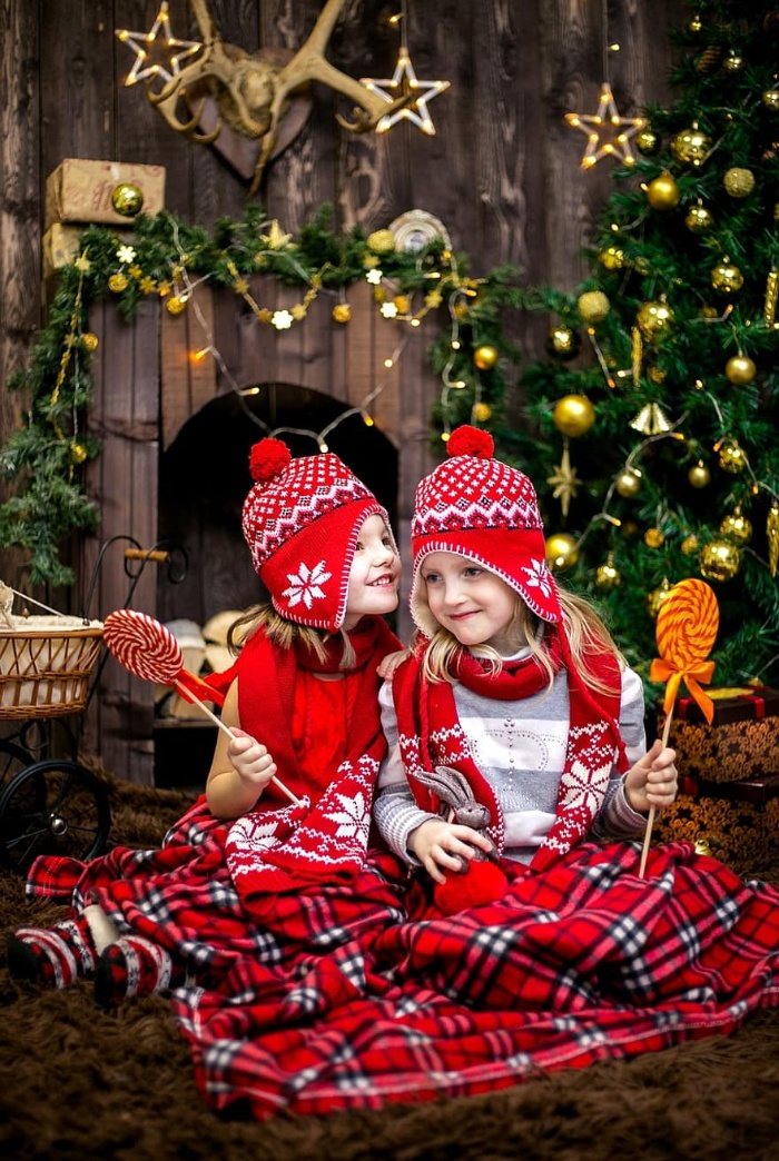 two girls dressed in a festive outfit with christmas decor in the background