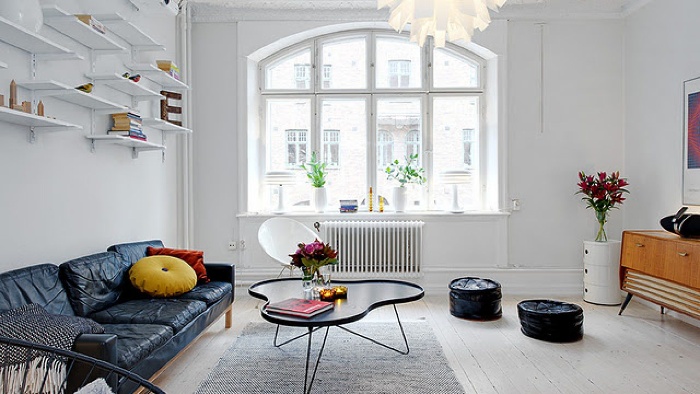 scandinavian design clean interior in white with black sofa and table wall shelves