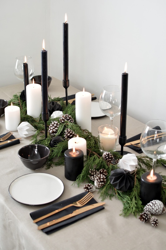 simple christmas design modern table with white and black candles and pinecones elegant table setting