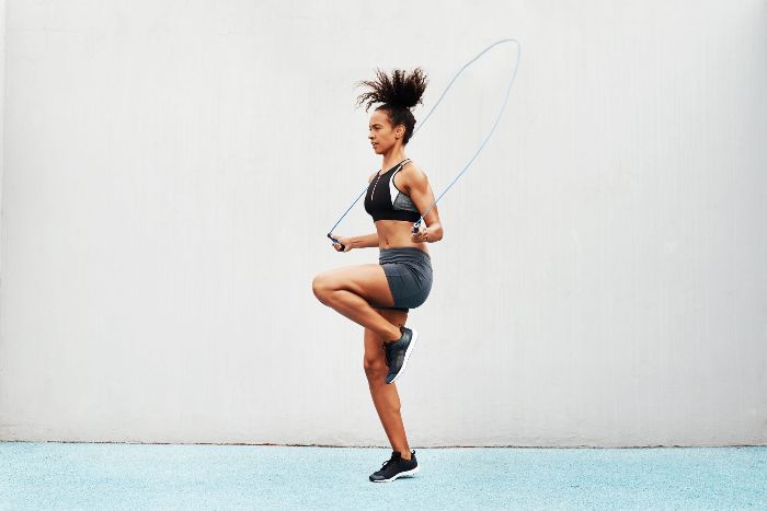 woman in sportswear jumping outdoors 