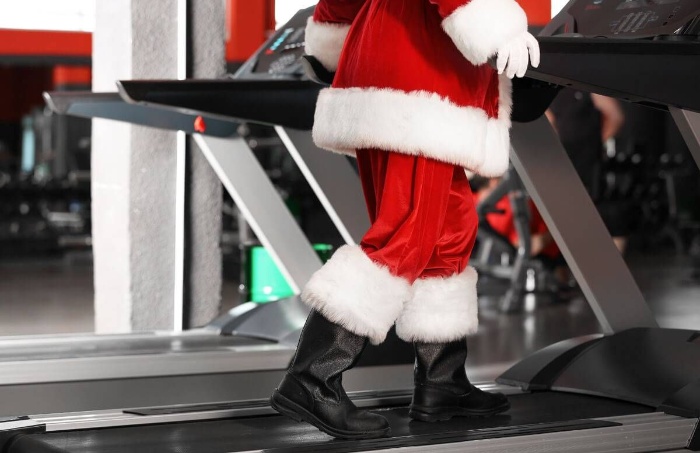 stay active during the holidays santa in a fitness room exercising