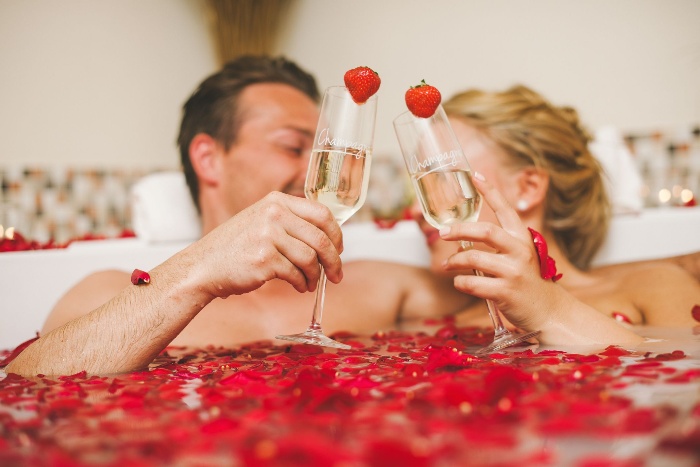 taking a bath together couple taking a bath full of rose petals with glasses decorated with strawberries