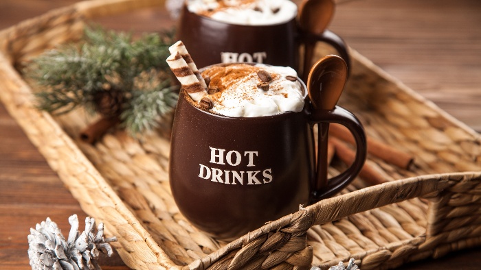 winter coffee in brown mugs with cream on top in a tray