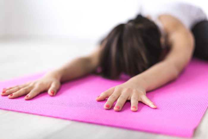 holiday season yoga and exercise woman on a pink yoga mat doing yoga