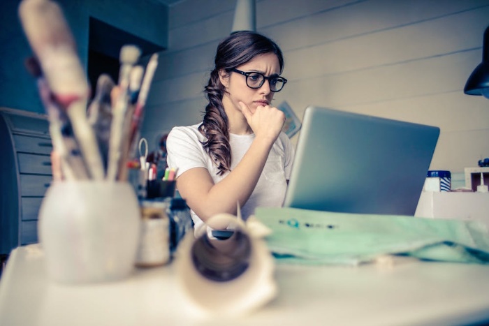 new year focus woman in her office in front of her computer with her glasses on