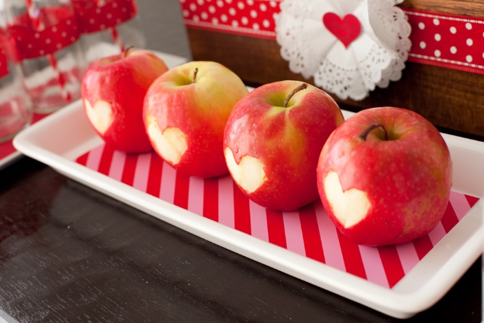 apples on a white tray with hearts carved in them