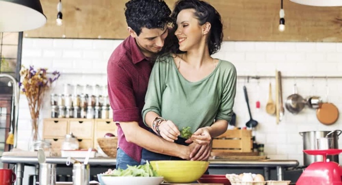 couple hugging and cooking together in a kitchen